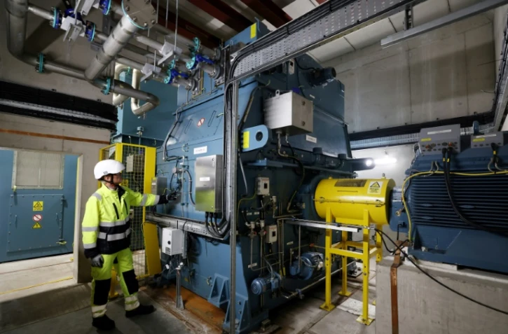 Guy Nicholson, responsable des solutions réseau neutres en carbone chez Statkraft, se tient près d'un volant d'inertie, le 7 août 2025 à Liverpool