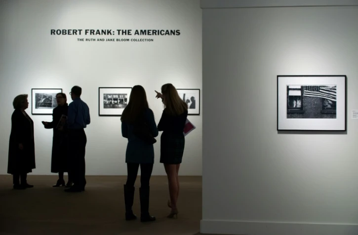 Des visiteurs regardent des images du photographe Robert Frank tirées de son livre "Les Américains", lors d'une exposition à Sotheby's à New York (Etats-Unis), le 17 décembre 2015.