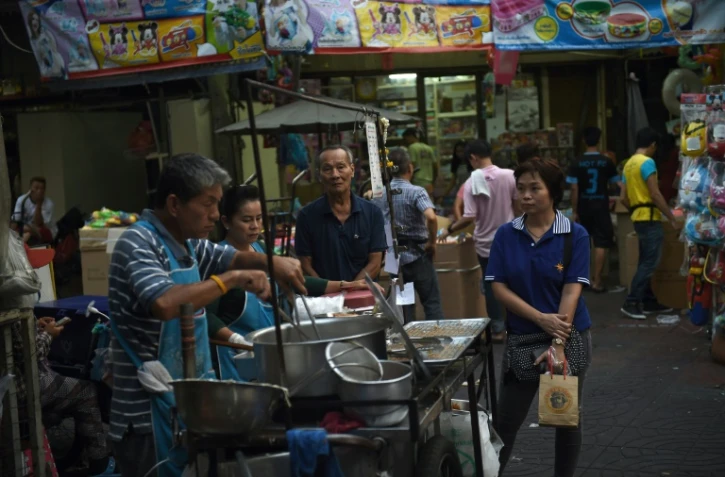 Un vendeur prépare à manger dans une allée du quartier chinois de Bangkok, le 12 avril 2016