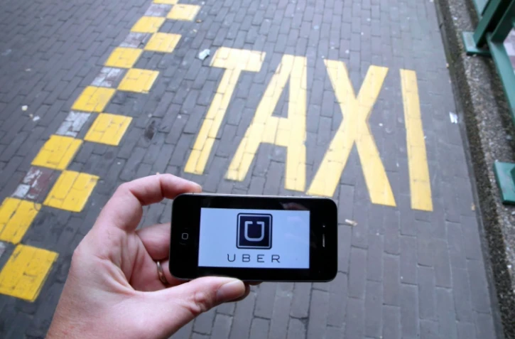 Le logo d'Uber affiché sur un smartphone pendant une manifestation de taxis à Bruxelles contre l'application, le 13 septembre 2015 
