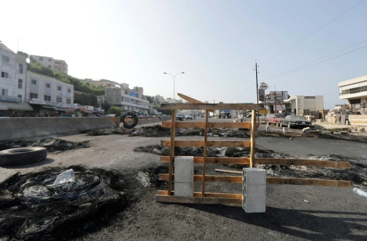 Des débris de barricades sur une autoroute reliant Beyrouth à Tripoli, le 19 octobre 2019 au Liban