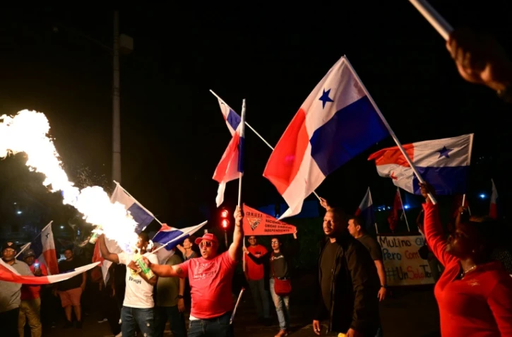 Un manifestant projette une flamme avec une bombe aérosol lors d'une manifestation contre la visite au Panama du secrétaire d'Etat américain Marco Rubio, à Panama, le 1er février 2025