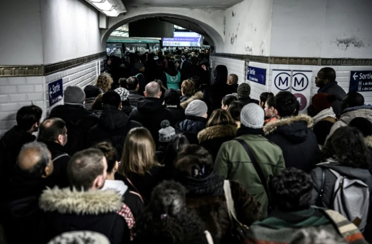 Des personnes font la queue pour accéder au quai de la ligne 1 du métro à Paris, au 8ème de grève dans les transports contre la réforme des retraites, le 12 décembre 2019