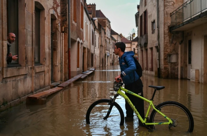 Deux personnes discutent dans une rue inondée de Montbard, dans la Côte d'Or, le 1er avril 2024