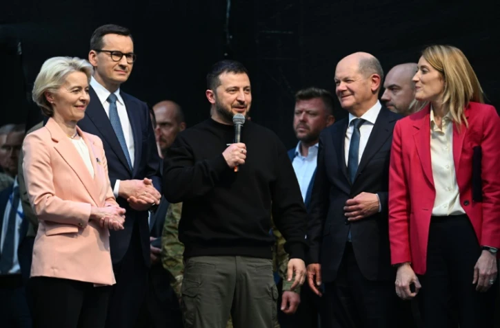 Le président ukrainien Volodymyr Zelensky (au centre) parle au micro, avec (de gauche à droite) la présidente de la Commission européenne Ursula von der Leyen, le Premier ministre polonais Mateusz Morawiecki, le chancelier allemand Olaf Scholz et la présidente du Parlement européen Roberta Metsola, le 14 mai 2023 à Aachen (Allemagne)