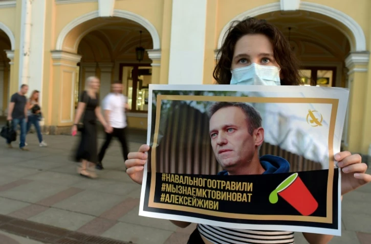 Une femme tient le portrait de l'opposant russe Alexeï Navalny à Saint-Pétersbourg, le 20 août 2020