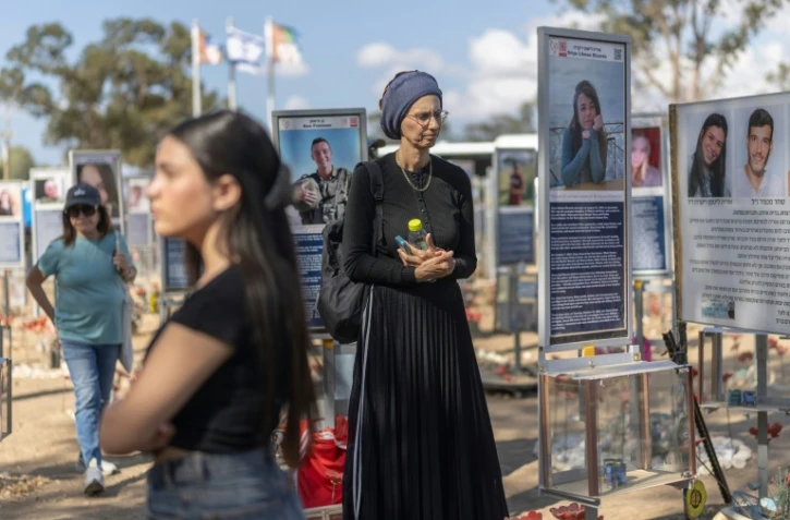Des Israéliennes se recueillent au mémorial dressé pour les victimes de l'attaque du 7-Octobre contre le festival Nova, le 6 octobre 2026 à Reim en Israël