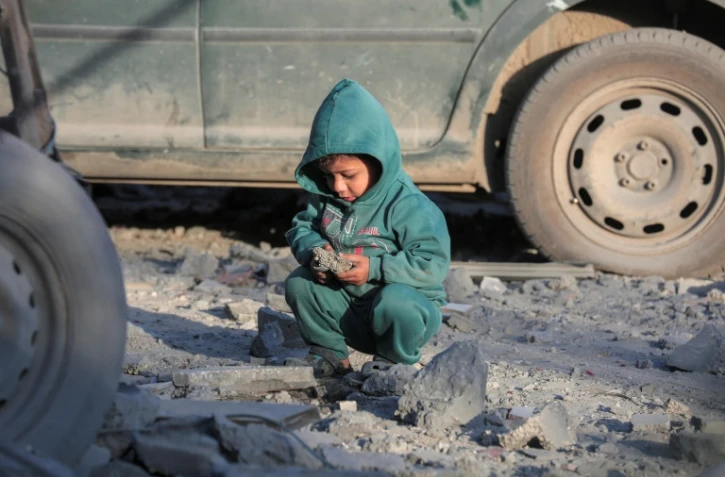 Un enfant palestinien assis au milieu des ruins d'une mosquée détruite par des frappes israëliennes à Deir El-Balah au mlieu de la bande de Gaza le 2 mars 2024