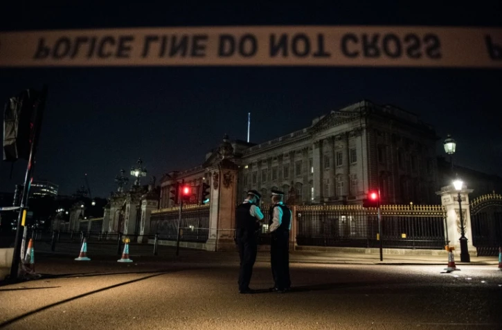 Des policiers montent la garde le 25 août 2017 devant le Palais de Buckingham, entouré d'un périmètre de sécurité après une attaque au couteau contre des policiers