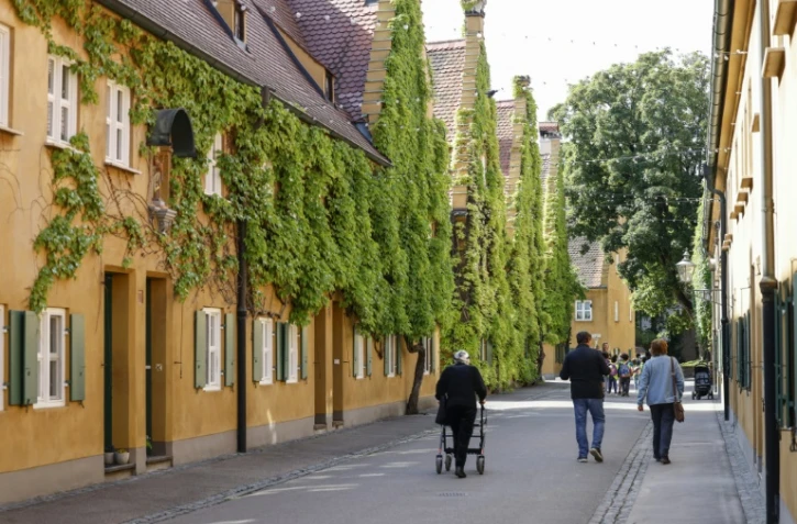 Des habitants dans une rue de la résidence "Fuggerei"  à Augsbourg, le 1er avril 2025 dans le sud de l'Allemagne