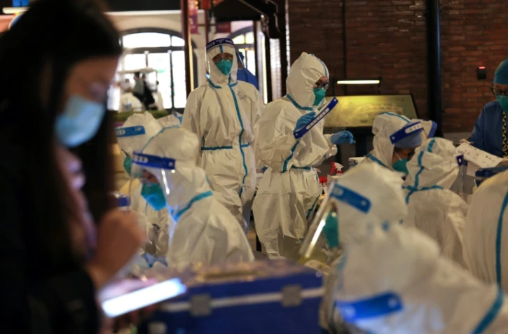 Des membres du personnel médical s'apprêtent à tester des visiteurs de Disneyland à Shangaï le 31 octobre 2021