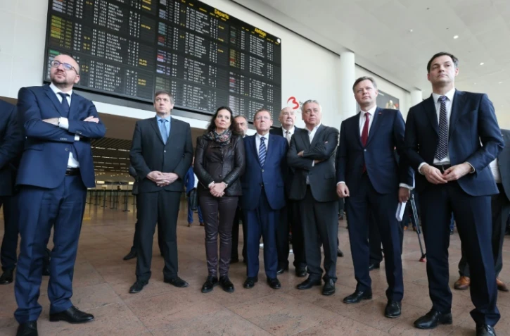 Le Premier ministre Charles Michel (g), et le ministre de l'Intérieur belge, Jan Jambon (2e g), à l'aéroport de Zaventem, près de Bruxelles, lors de la cérémonie de réouverture du hall des départs, fermé depuis les attentats du 22 mars dernier