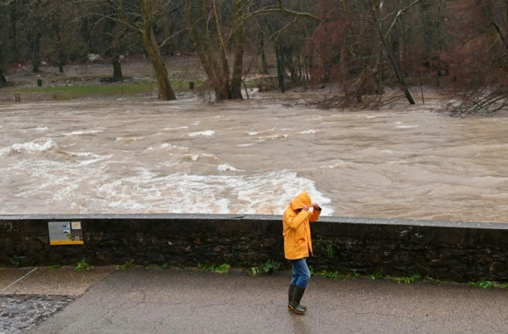 Un passant sur les berges de l'Hérault, qui a débordé suite aux fortes pluies à Laroque, le 22 décembre 2025