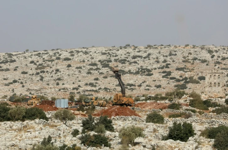 Une photo prise le 24 octobre 2017 montre des soldats de l'armée turque et des véhicules blindés sur une colline dans la région de Darret Ezza en Syrie, près de la frontière turque