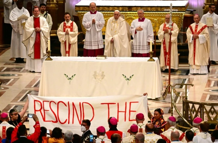 Une banderole déployée par des manifestants pendant la messe célébrée par le pape François à Sainte-Anne-de-Beaupré, le 28 juillet 2022 au Québec