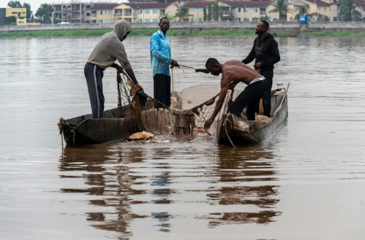 Des pĂȘcheurs rĂ©cupĂšrent des dĂ©chets plastiques pris dans l'un de leurs filets sur le fleuve Congo Ă Kinshasa, le 27 avril 2026 en RDC