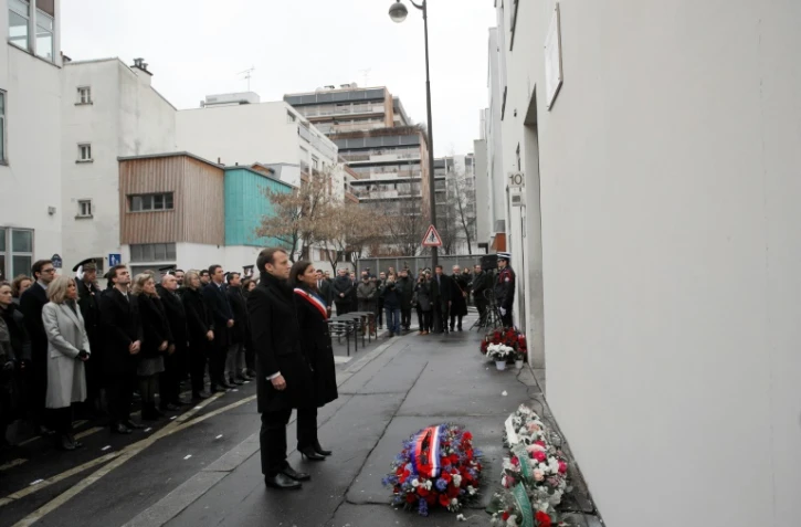 Emmanuel Macron (C) et Anne Hidalgo observent une minute de silence, le 7 janvier 2018 en hommage aux victimes des attaques jihadistes contre Charlie Hebdo et l'Hyper Cacher Ă Paris