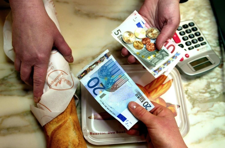 Une personne achète sa baguette de pain, le 2 janvier 2002, dans une boulangerie de Lille, avec un billet de 20 euros