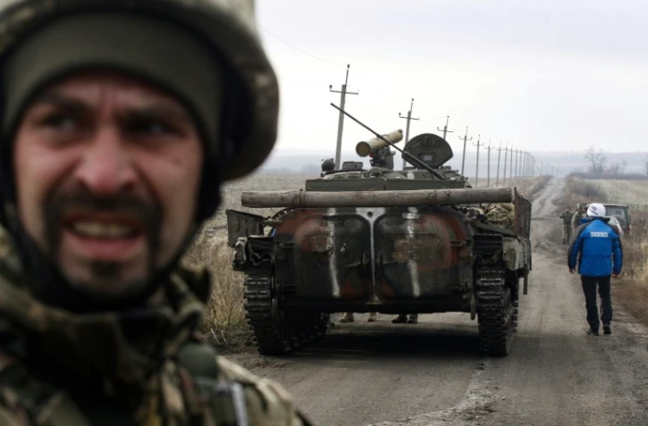 Un observateur de l'OSCE près d'un tank lors d'une mission d'observation du retrait des forces ukrainiennes près du village de Bogdanivka, dans la région de Donetsk en Ukraine, le 9 novembre 2019
