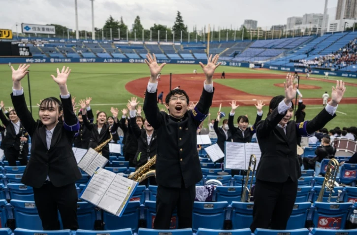 Des membres de l'"oendan" de l'Université Meiji encouragent leur équipe lors d'un match de baseball, le 13 mai 2023 à Tokyo