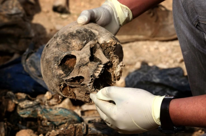 Des membres de la minorité yazidie en Irak cherchent des preuves pouvant leur permettre de retrouver des proches disparus ou tués par le groupe Etat islamique (EI), dans un charnier près du village de Sinuni, dans la région de Sinjar (nord-ouest), le 3 février 2015