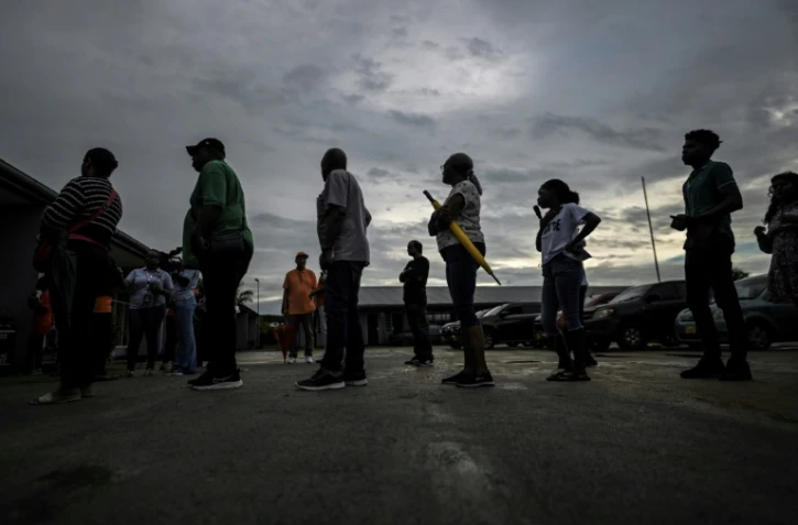 Des électeurs attendent pour voter lors des élections législatives, le 25 mai 2025 à Paramaribo, au Suriname