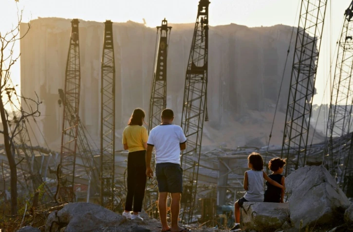 Un couple et des enfants regardent les dommages causés il y a dix jours par l'explosion du port de Beyrouth, le 13 août 2020