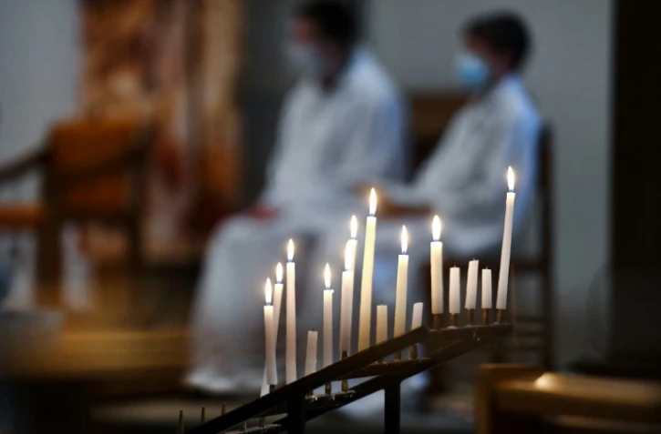 Sur cette photo d'illustration prise le 27 mars 2021, des bougies votives brûlent durant une messe à Brest, dans l'ouest de la France