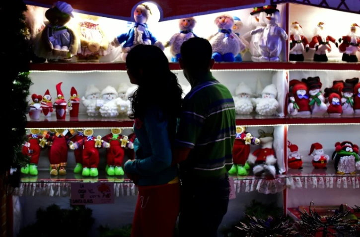 Des passants regardent des décorations de Noël dans une boutique à Tlalpujahua, dans l'Etat du Michoacan, le 16 décembre 2016 au Mexique