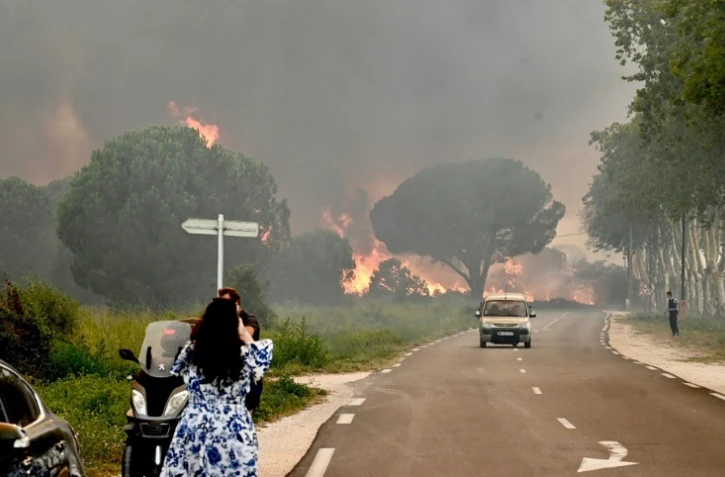 Une femme prend en photo l'incendie qui frappe plusieurs communes des Pyrénées-Orientales, dont Argelès-su-Mer, le 14 août 2024