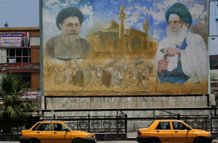 Une affiche représentant le dirigeant shiite Moqtada al-Sadr (g) et le membre du clergé shiite Mohammed Baqer al-Sadr, à Sadr City, le 14 mai 2018