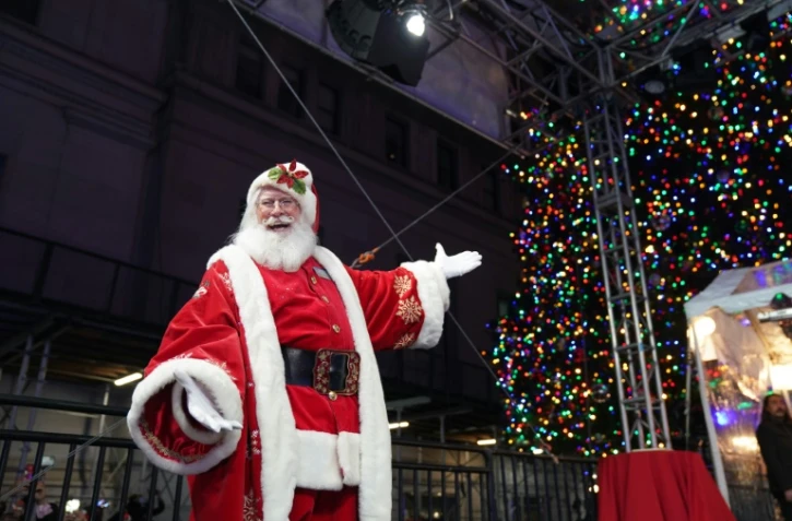 Sur cette photo du 1er décembre 2021 à New York, un père Noël assiste à l'illumination du sapin de Noël devant la Bourse de Wall Street.