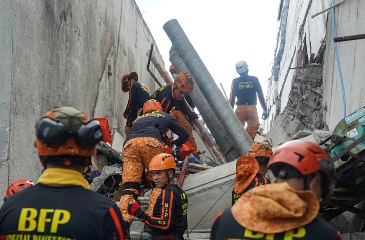Des secouristes sur le site d'un bâtiment effondré après un séisme de magnitude 7,8 à General Santos, le 8 juin 2026 aux Philippines