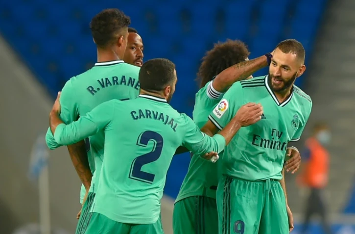 L'attaquant français du Real Madrid, Karim Benzema (d), félicité par ses coéquipiers après son but lors du match de Liga face à la Real Sociedad, à San Sebastian, le 21 juin 2020