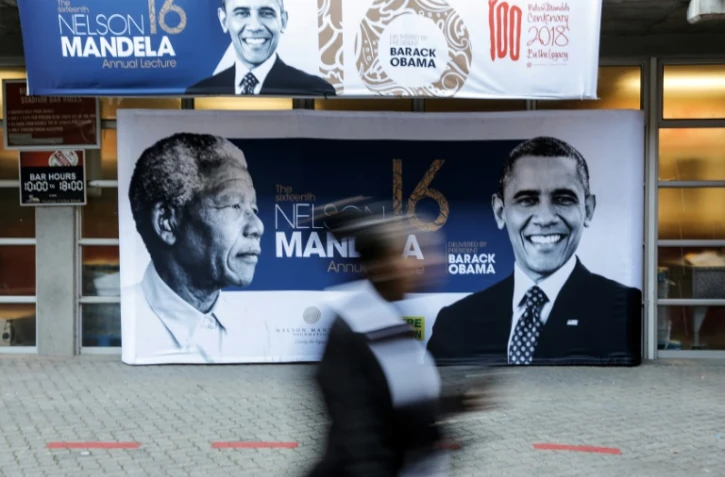 Les portraits de Nelson Mandela et de Barack Obama sur une affiche à l'entrée du stade Wanderers, le 17 juillet 2018 à Johannesburg, où l'ancien président américain prononcera un discours, point d'orgue des célébrations du centième anniversaire de la naissance du premier chef d'Etat noir sud-africain