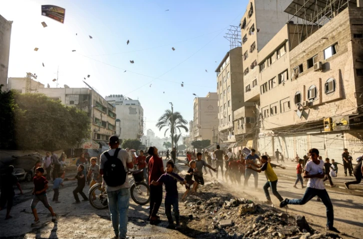 Des habitants de Gaza-ville assistent à un lâcher de tracts par l'armée israélienne appelant à l'évacuation de la ville, le 9 septembre 2025