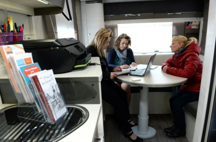 Un conseiller des services publics itinérants aide les habitants à s'acquitter de leurs procédures administratives, le 27 avril 2017 dans un camping-car garé à Lesquielles-Saint-Germain