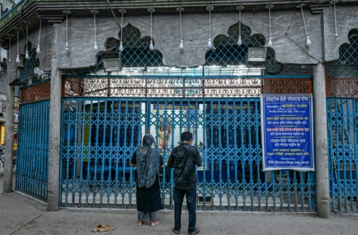 Un couple d'Hindous prie devant un temple à Dacca le 9 août 2024