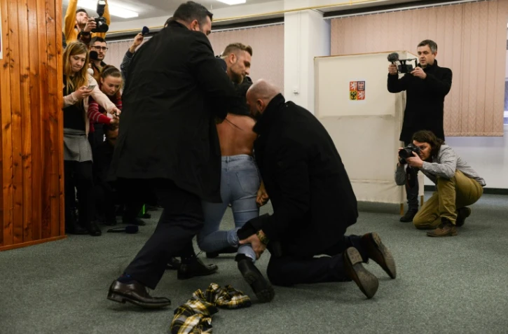 Les membres de la sécurité du président tchèque Milos Zeman interpellent une Femen à Prague, le 12 janvier 2018
