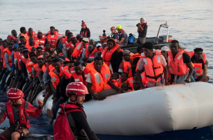 Photo fournie le 22 juin 2018 par l'ONG allemande Mission Lifeline, montrant des migrants secourus le 21 juin en mer et embarquant à bord du navire Lifeline qui va chercher des migrants en Méditerranée 