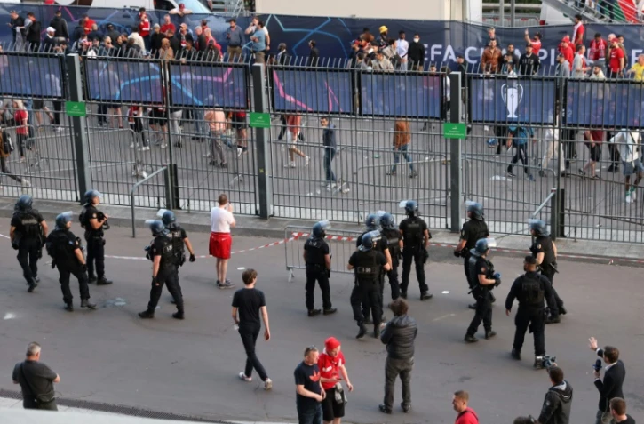 Des policiers en position près des barrières entourant le Stade de France pour empêcher des tentatives d'intrusion d'individus sans billet, lors de la finale de Ligue des champions, le 28 mai 2022 à Saint-Denis, au nord de Paris
