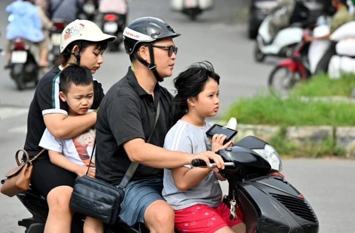 Une famille se déplace en motocyclette, le 4 juin 2025 à Hanoï