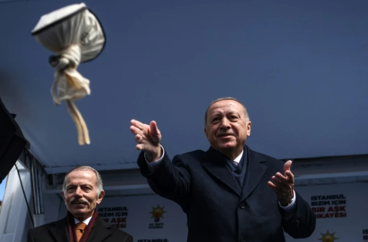 Le président turc Recep Tayyip Erdogan lance un sac de thé noir à ses partisans lors d'un meeting électoral pour les municipales, le 30 mars 2019 à Istanbul