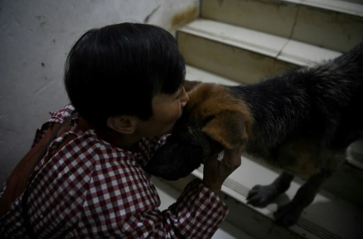 Mme Wen embrasse un chien dans sa maison de Chongqing (Chine) le 29 novembre 2020