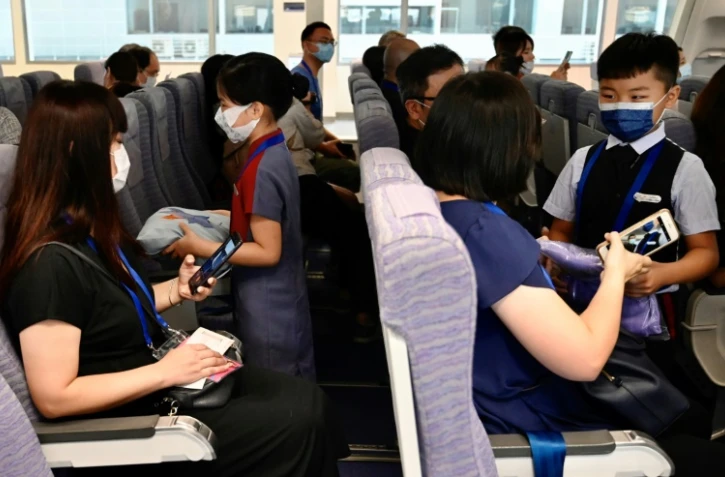 Des enfants et leurs parents jouent les rôles de personnel de cabine et de passagers au siège de China Airlines, à Taoyuan (Taïwan) le 8 août 2020