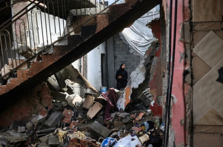 Une Palestinienne constate les dégâts causés à une maison par les bombardements dans le centre de la bande de Gaza, le 15 juillet 2024