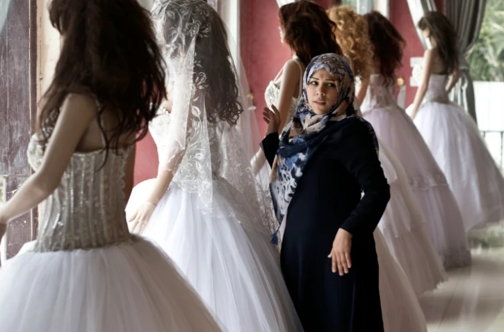 Une jeune Palestinienne regarde des robes de mariées dans une boutique à Gaza, le 5 avril 2016