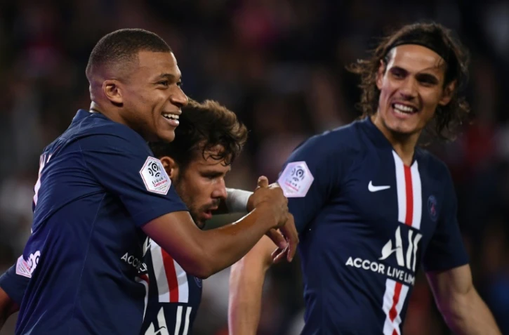 L'attaquant du PSG Kylian Mbappé (g) félicité par Juan Bernat (c) et Edinson Cavani après son but contre Nîmes, le 11 août 2019 au Parc des Princes
