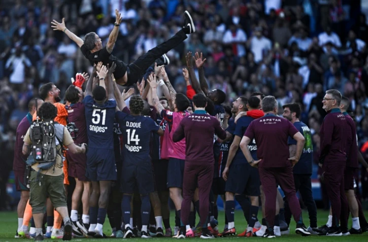 Les joueurs du Paris SG portent en triomphe et jettent en l'air leur entraîneur Luis Enrique après la conquête de leur titre de champions de France samedi au Parc des princes.