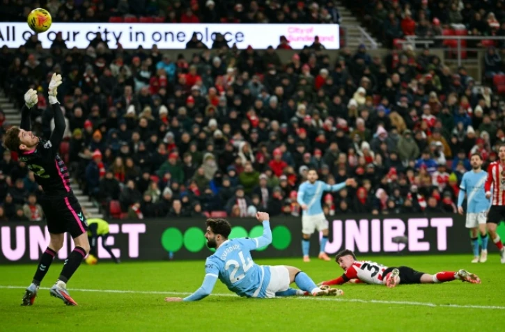 Le gardien de Sunderland Robin Roefs (à gauche) dégage une frappe de la tête de Josko Gvardiol (au centre) lors du match de Premier League contre Manchester City le 1er janvier 2026 à Sunderland
